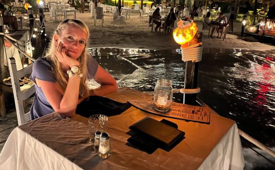 Rianna looking in the camera having dinner on an island