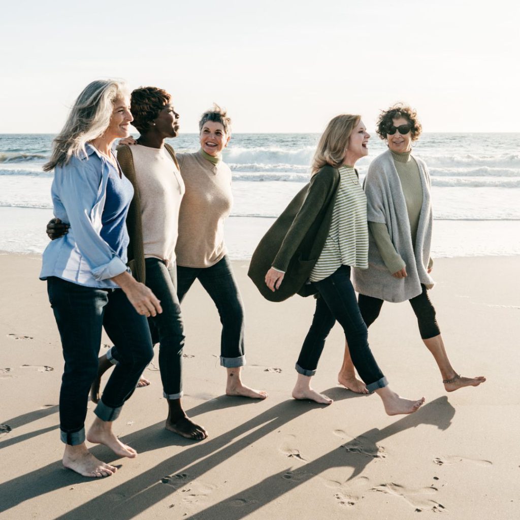 women walking on the beach talking, authentically connecting with each other